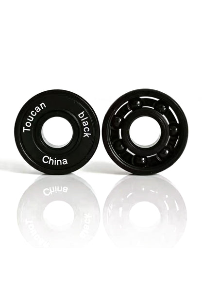 Toucan Black Pro ABEC-9 bearings, one with its rubber seal and one open showing the black ceramic balls